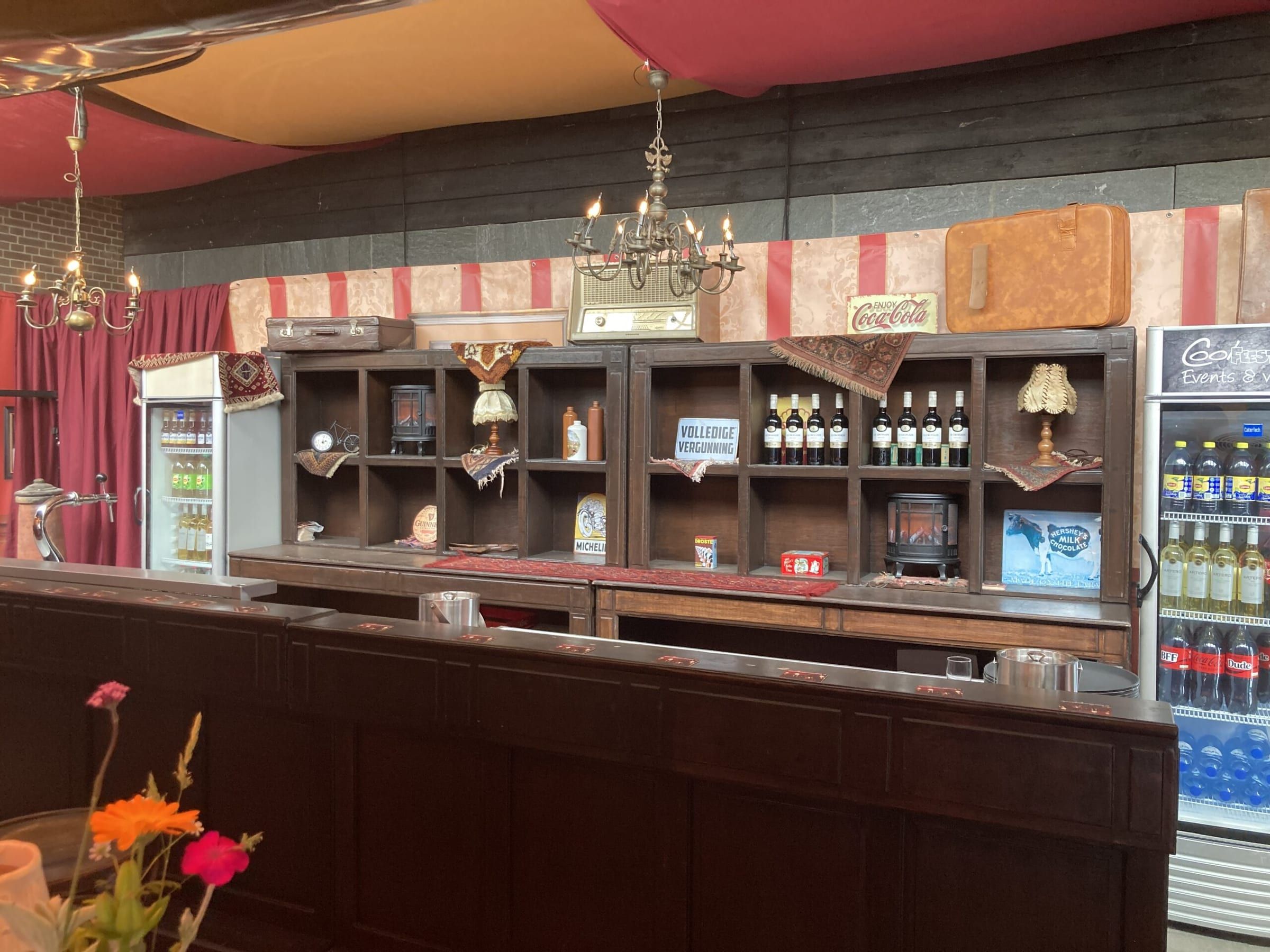 Houten bar met flessenrek en koelkasten, klaar voor het feest