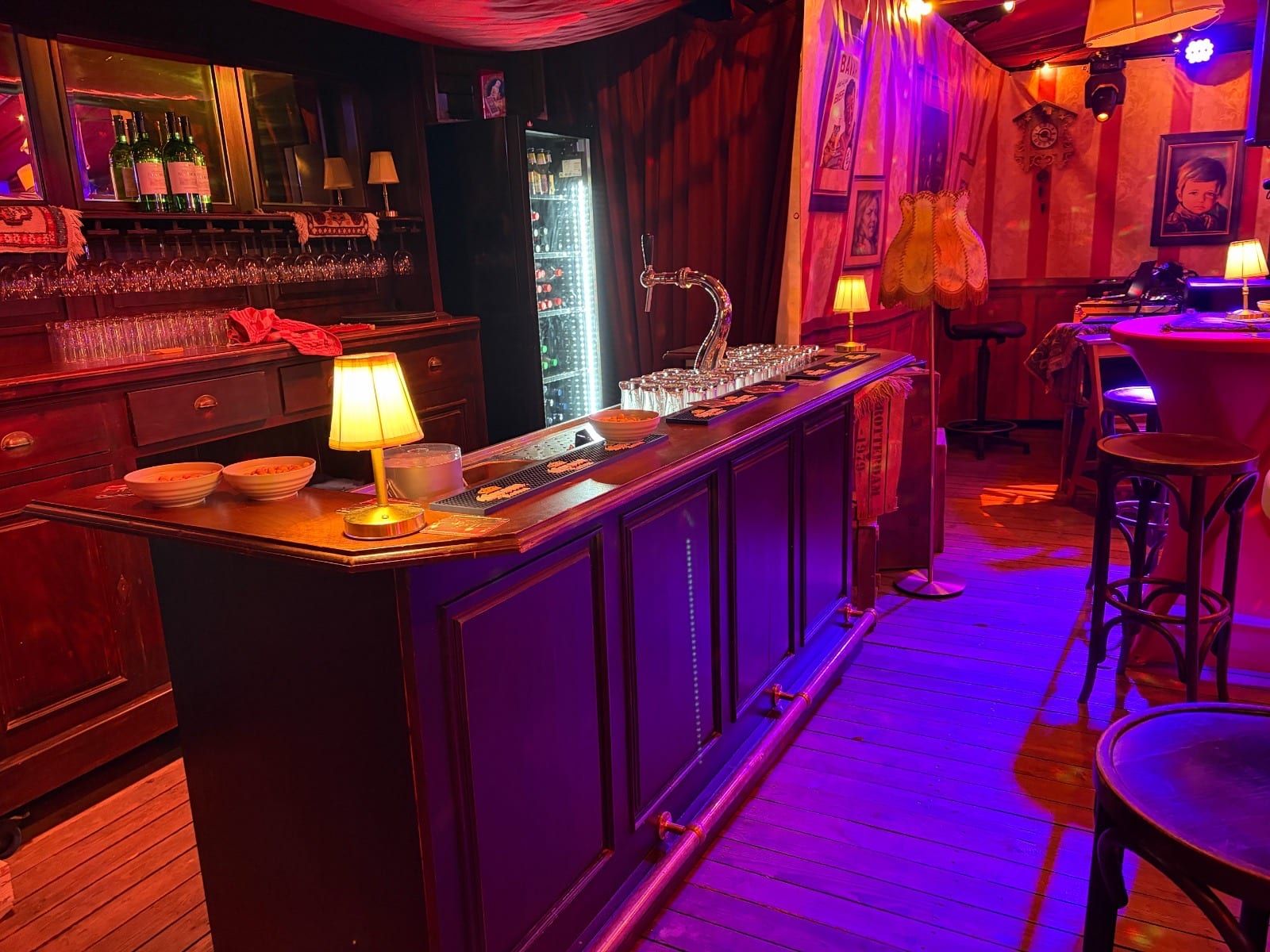 Bar met schemerlamp en lampjes in paars en rood licht